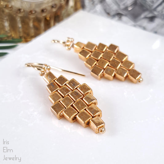 Gold cube geometric diamond glass earrings on a white surface with 'Iris Elm Jewelry' branding.