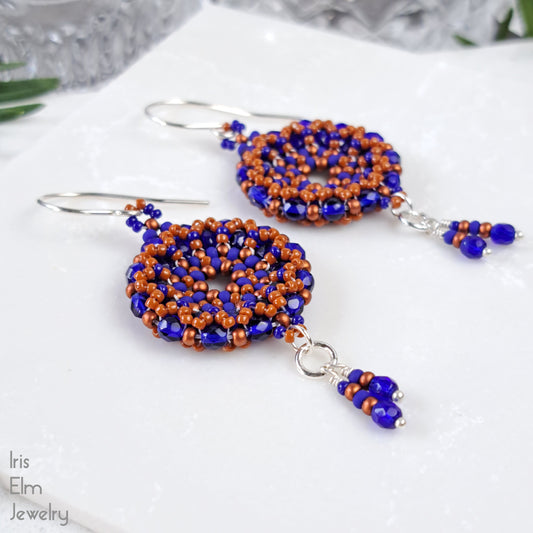 Beaded czech glass wreath earrings with blue and orange beads on a white surface, branded 'Iris Elm Jewelry'.