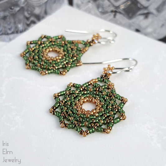 Green and golden mandala beaded earrings on a white surface with 'Iris Elm Jewelry' branding.