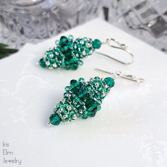 Green beaded bead glass earrings on a white surface with 'Iris Elm Jewelry' branding.