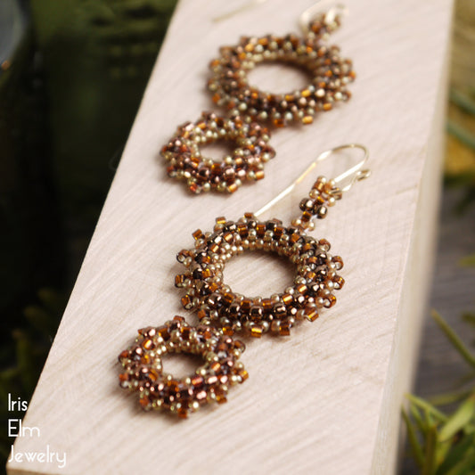 Pair of beaded double wreath brown seed bead earrings on a white card with 'Iris Elm Jewelry' branding.
