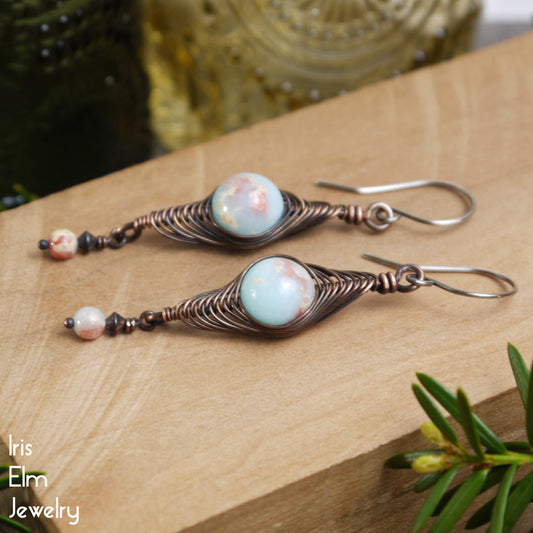 Pair of handmade copper wire wrapped earrings with jasper stones on a wooden surface, featuring 'Iris Elm Jewelry' branding.