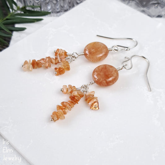 Orange agate and sunstone stone sterling silver earrings on a white surface with 'Iris Elm Jewelry' branding.