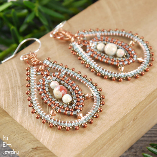 Beaded copper impression jasper teardrop beadwork earrings on a wooden surface with 'Iris Elm Jewelry' branding.