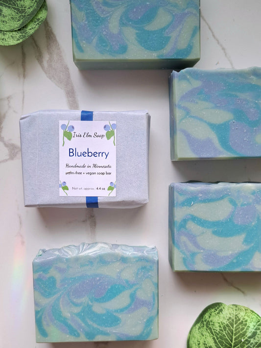 Blueberry handmade soap bars with packaging on a light surface