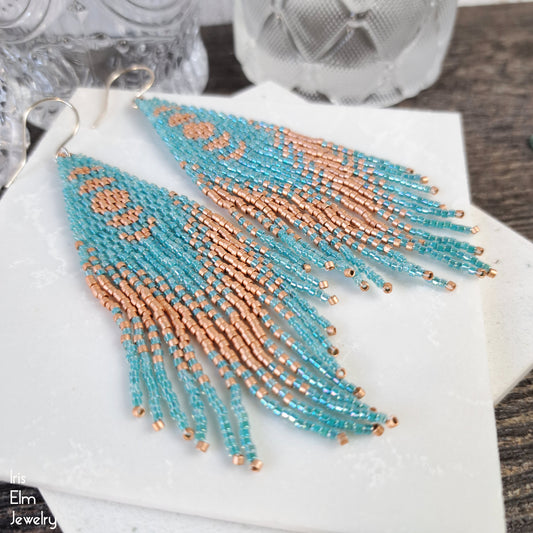aqua and matte copper glass seed bead fringe beaded earrings on a white surface with 'Elm Jewelry' branding.