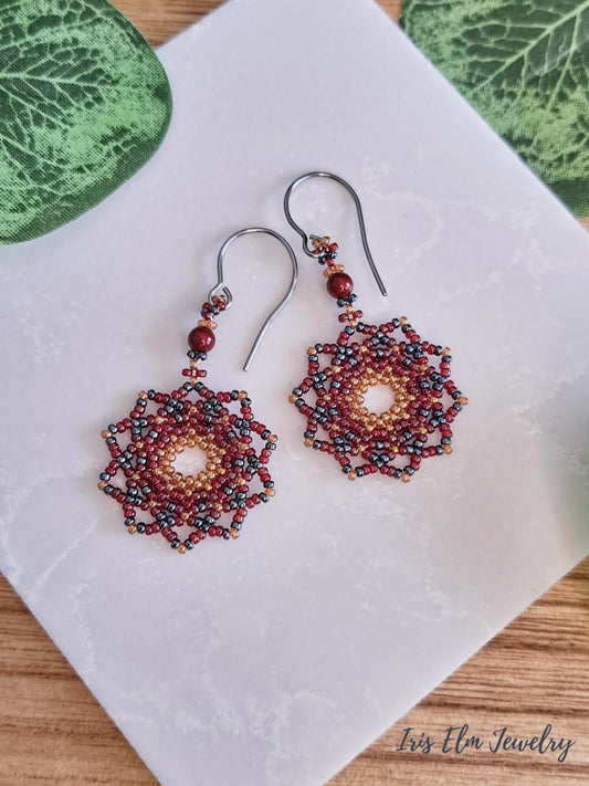 Beadwoven red mandala seed bead earrings on white stone 