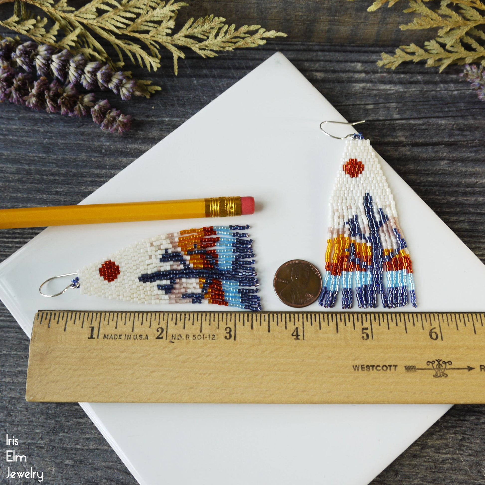 3.25 inch long cactus fringe earrings by a ruler for scale, on a wooden surface