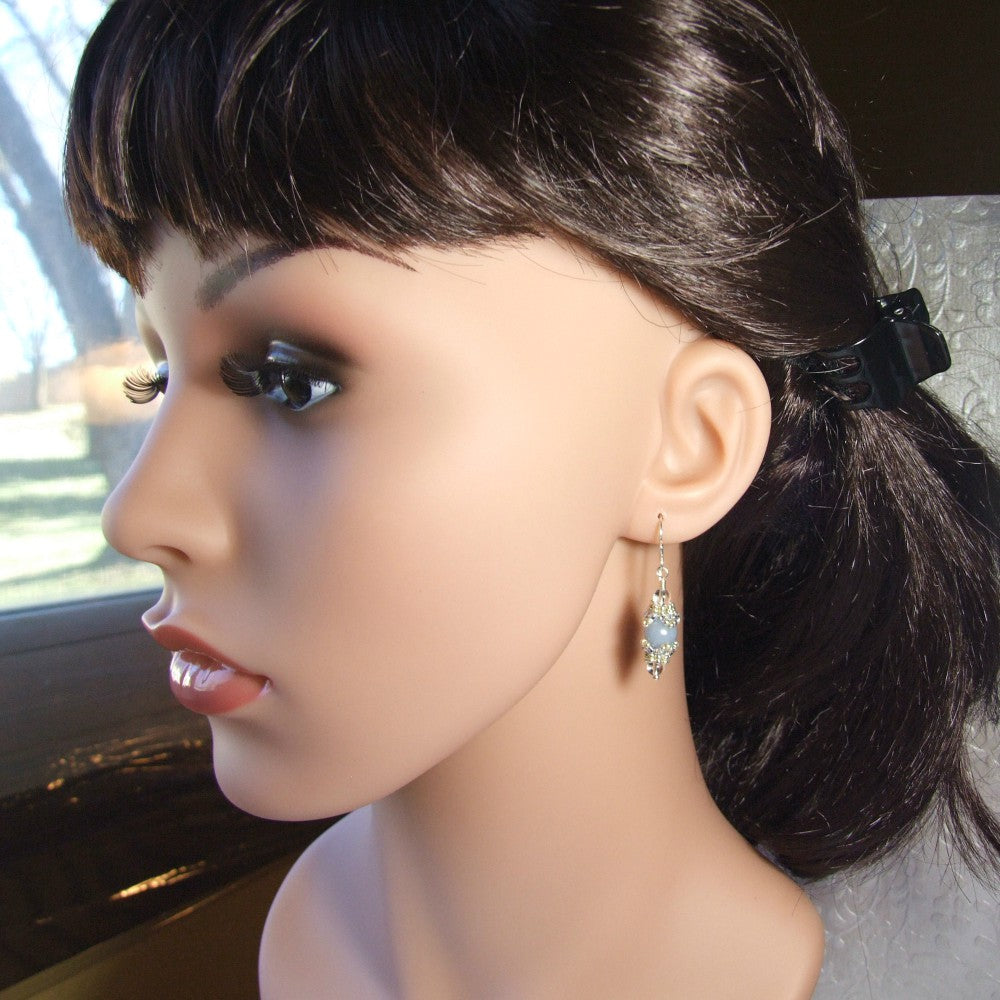 Mannequin head with dark hair and angelite earrings.