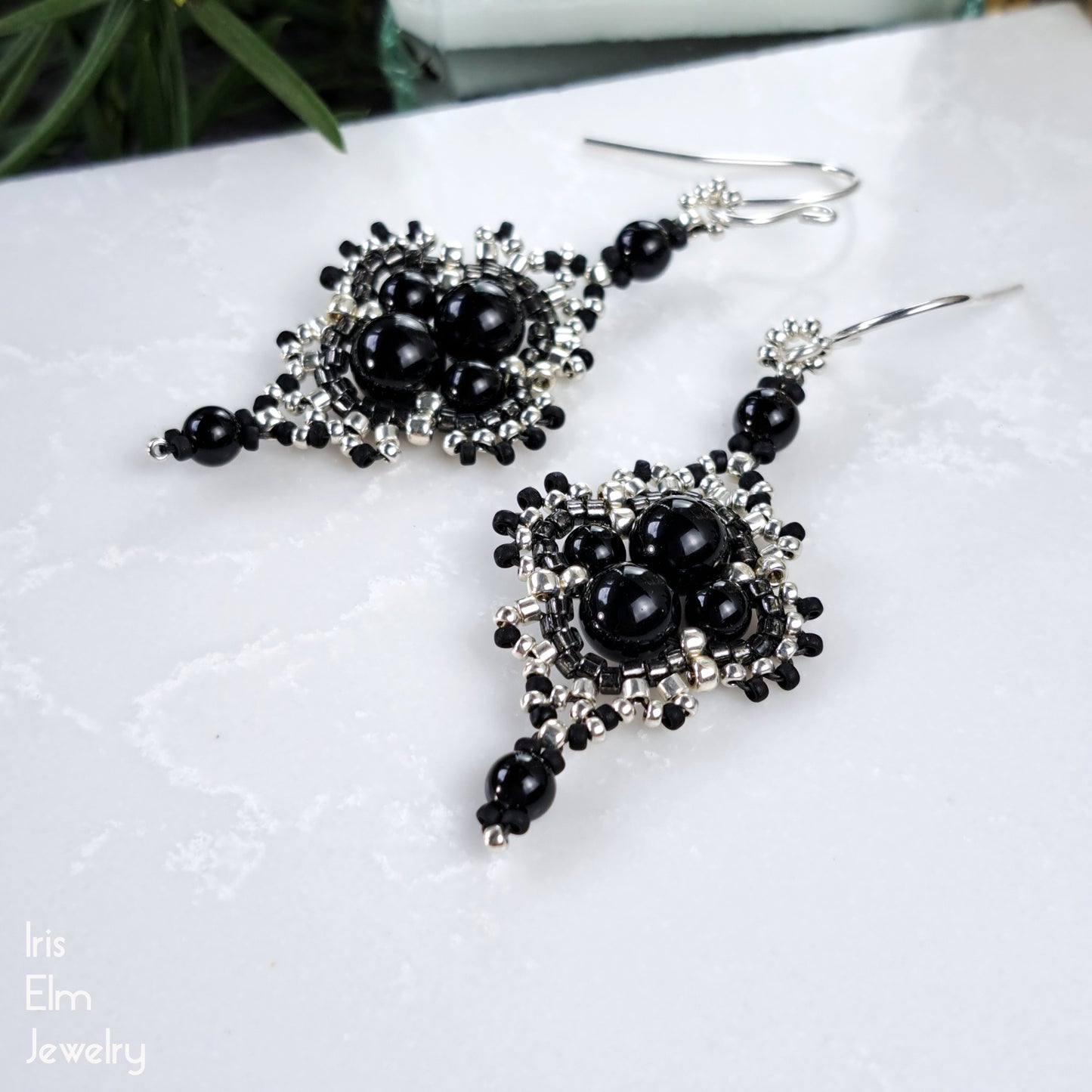 Black onyx gemstone beaded earrings on a white surface with 'Iris Elm Jewelry' branding.