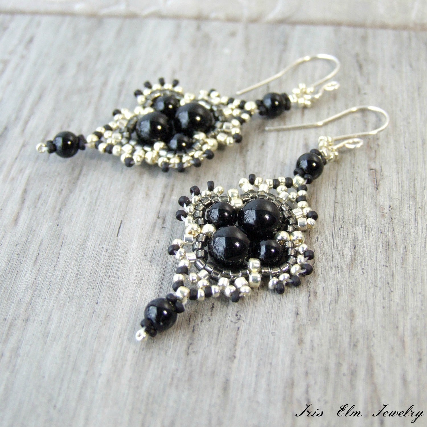 Black onyx and silver and grey seed bead beaded earrings on a wooden surface