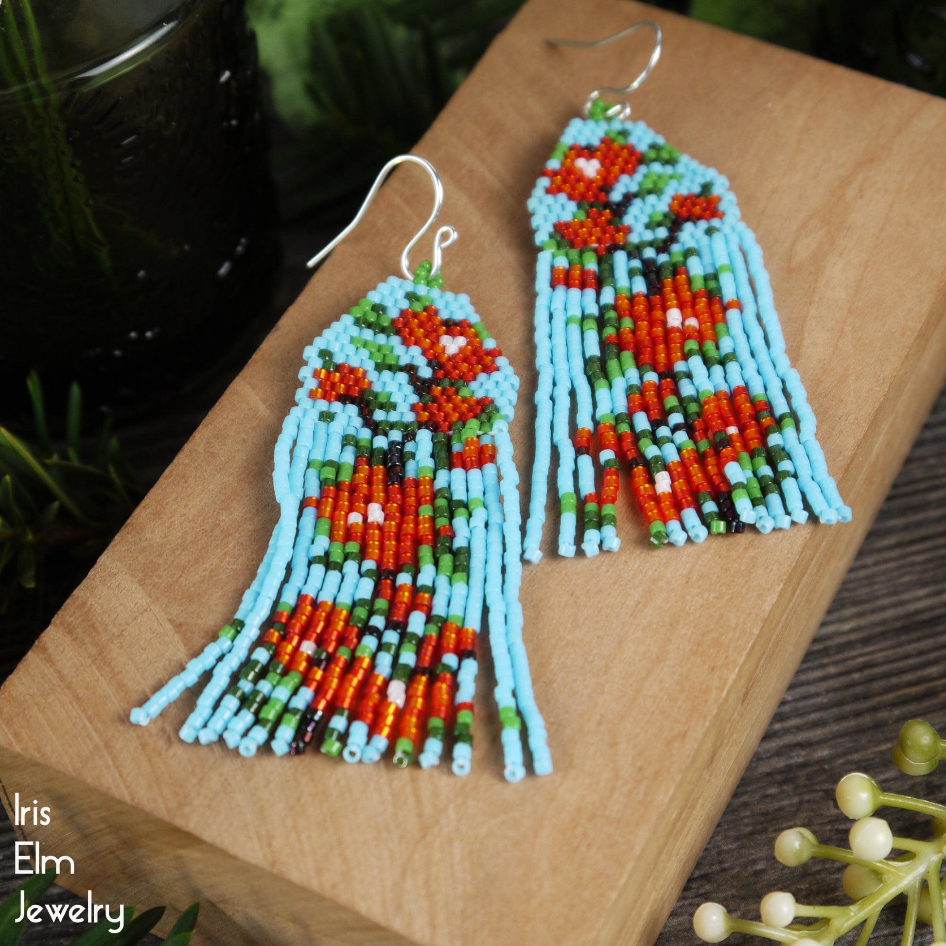beadwork seed bead flower fringe glass earrings on a wooden block with 'Iris Elm Jewelry' branding.