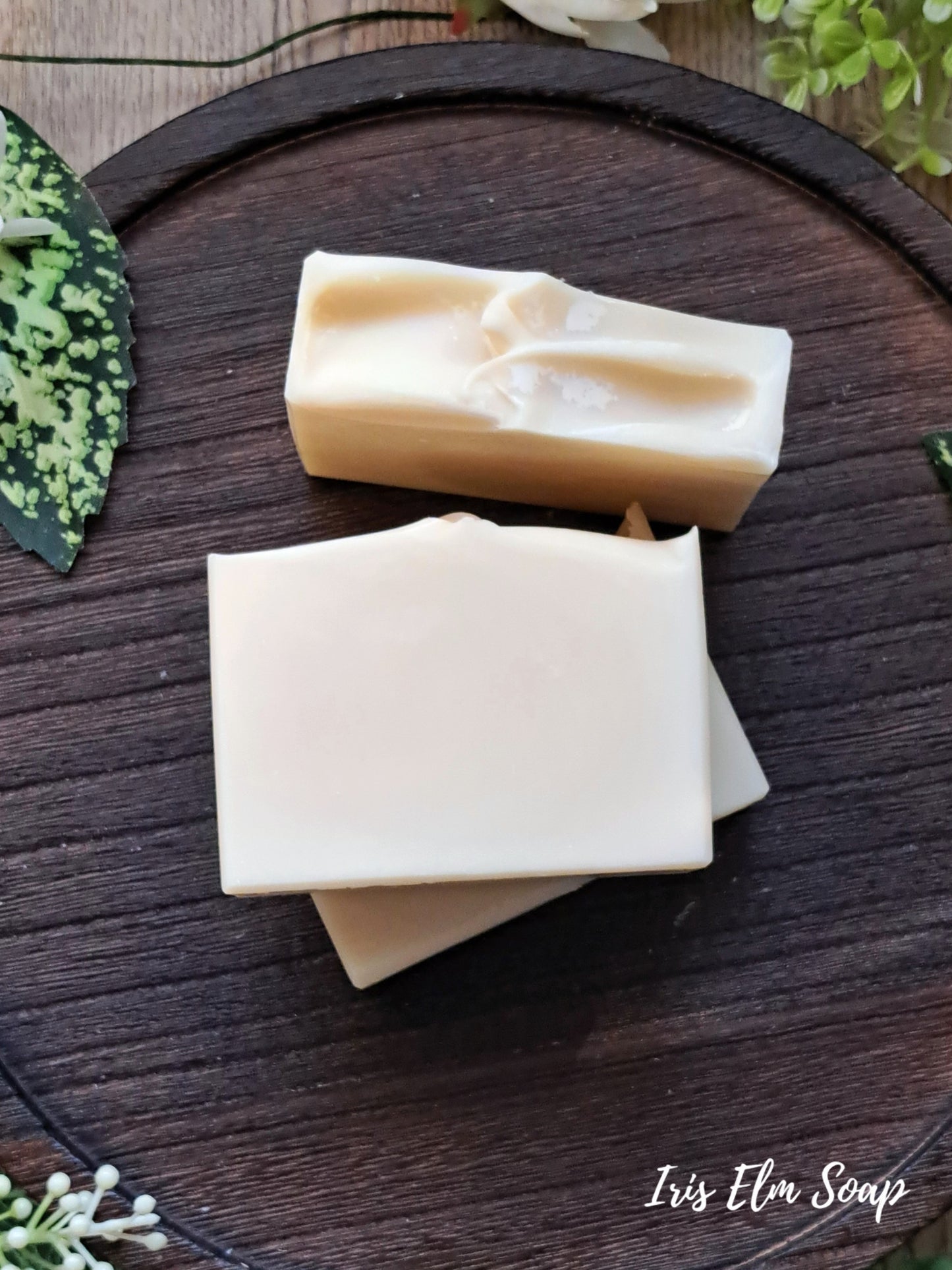 Two bars of unscented coconut milk handmade soap on a wooden surface with 'Iris Elm Soap' branding.