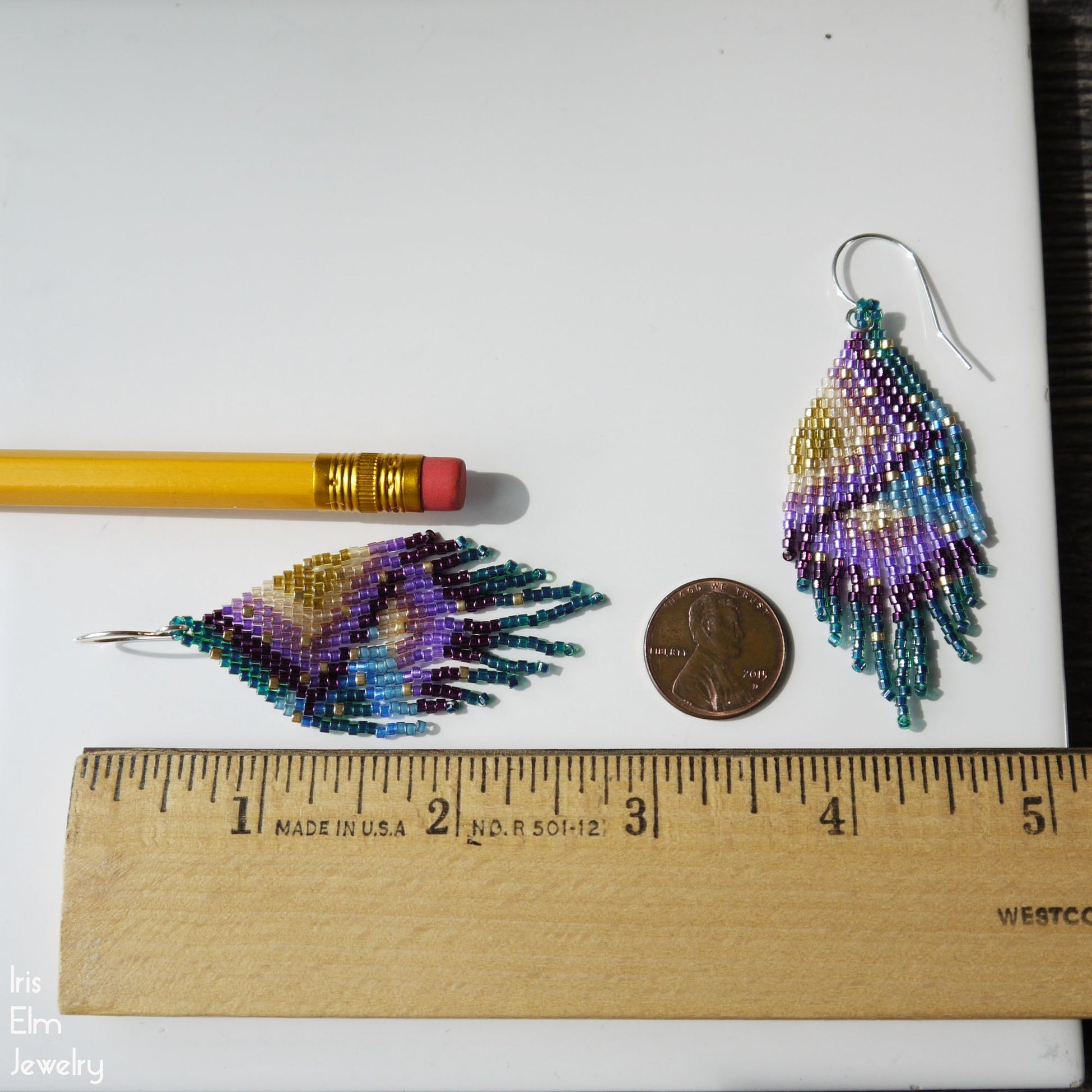 2.75 inch long Beaded earrings next to a pencil and coin on a white background with a ruler for scale.