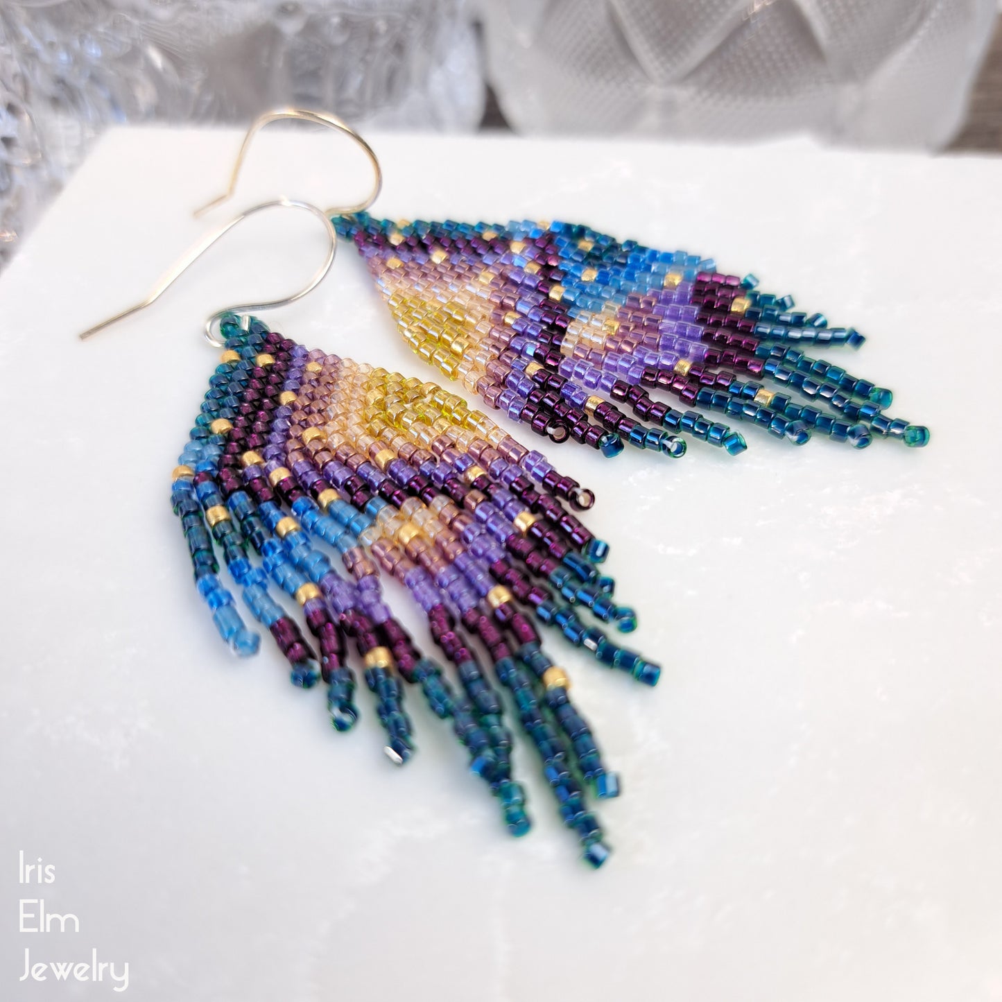 handmade beadwoven Colorful beaded earrings on a white surface with 'Iris Elm Jewelry' branding.