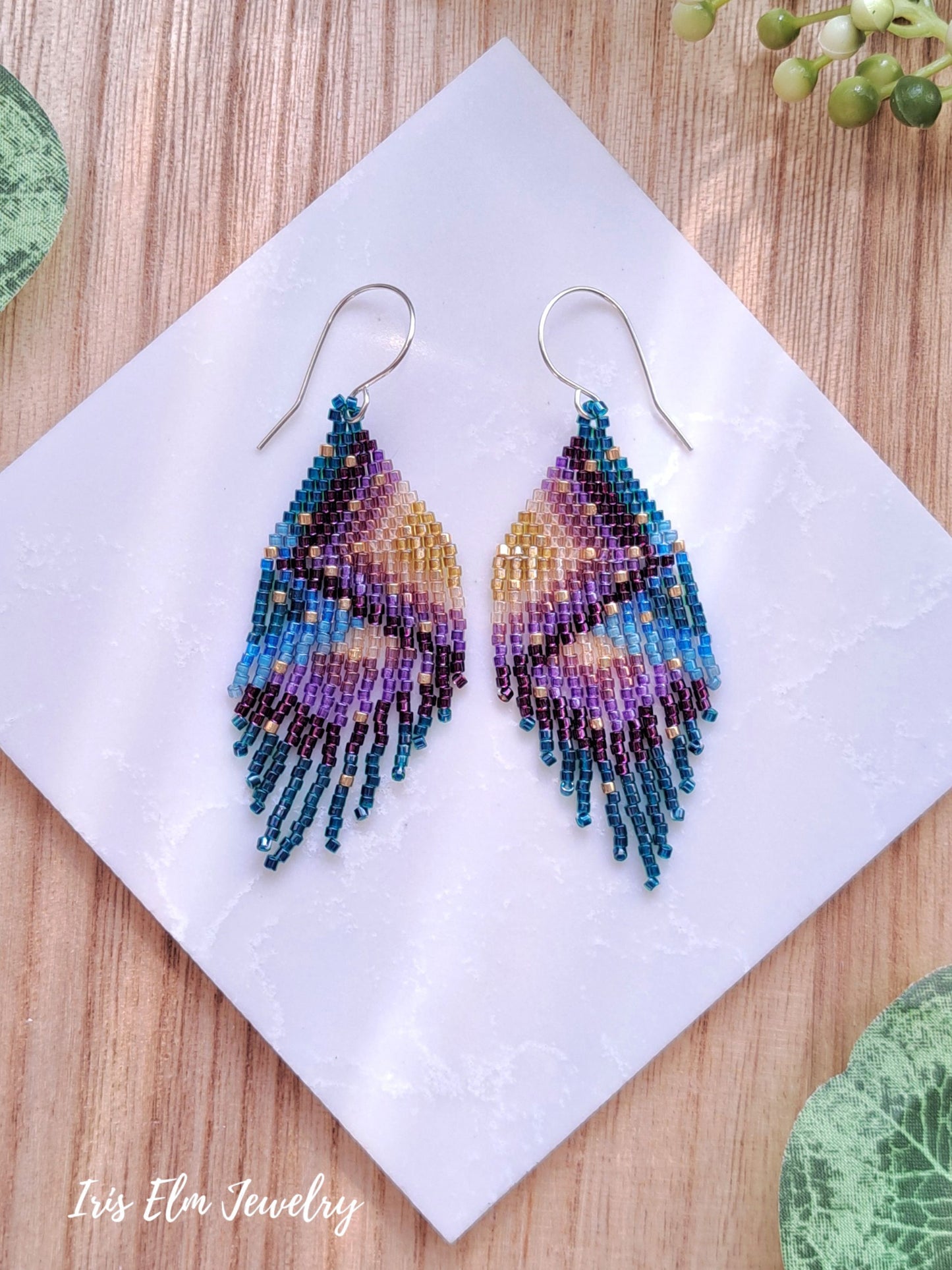 Colorful beaded seed bead fringe earrings on a white napkin with 'Iris Elm Jewelry' branding.
