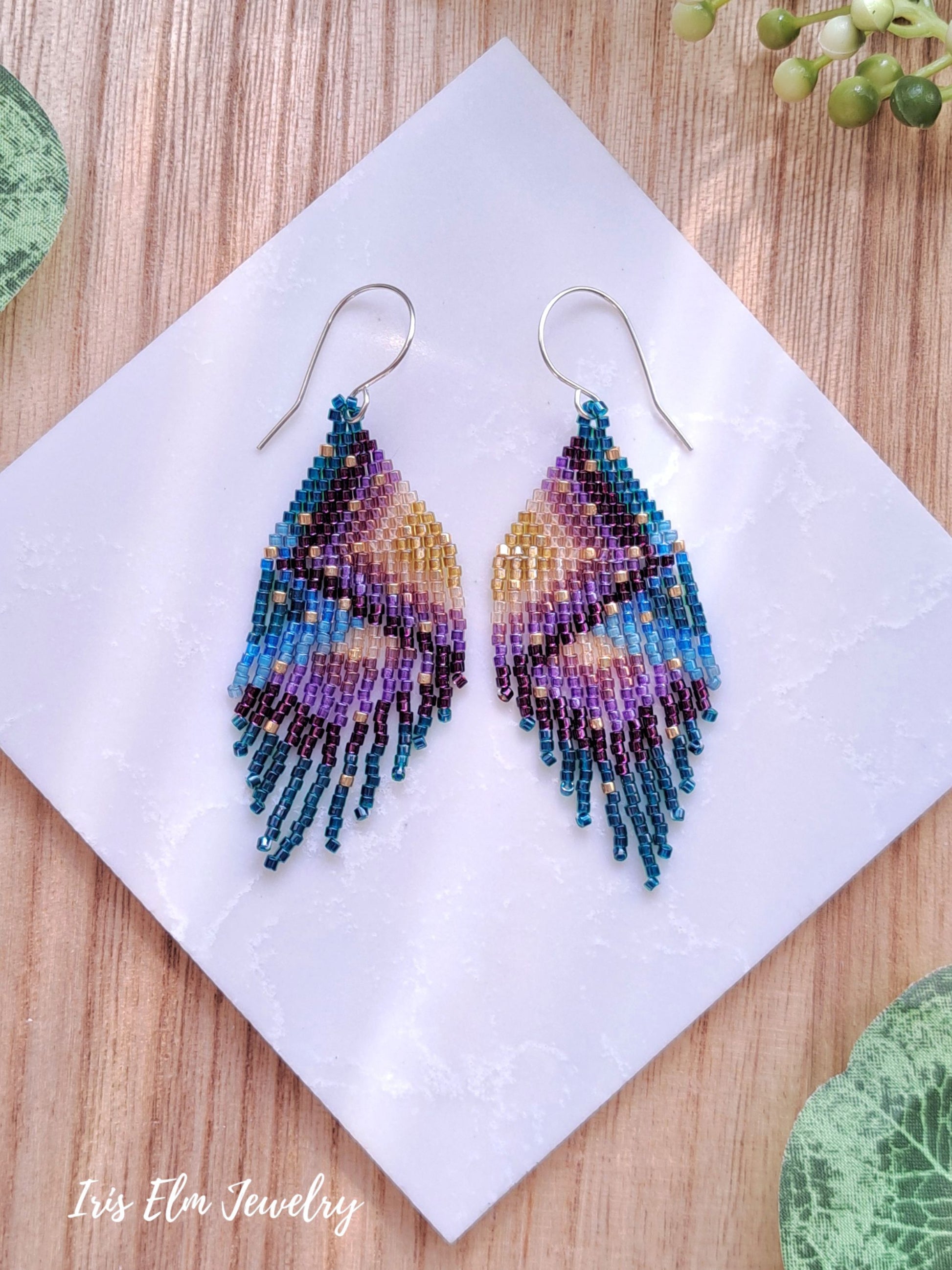 Colorful beaded seed bead fringe earrings on a white napkin with 'Iris Elm Jewelry' branding.