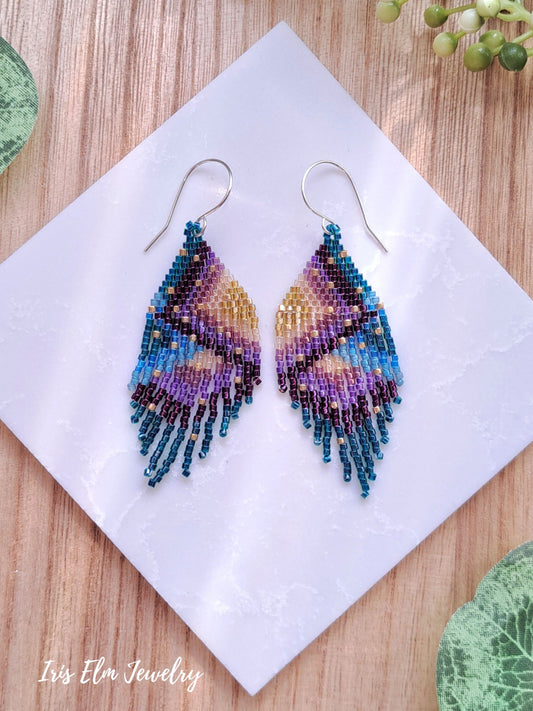 Colorful beaded seed bead fringe earrings on a white napkin with 'Iris Elm Jewelry' branding.