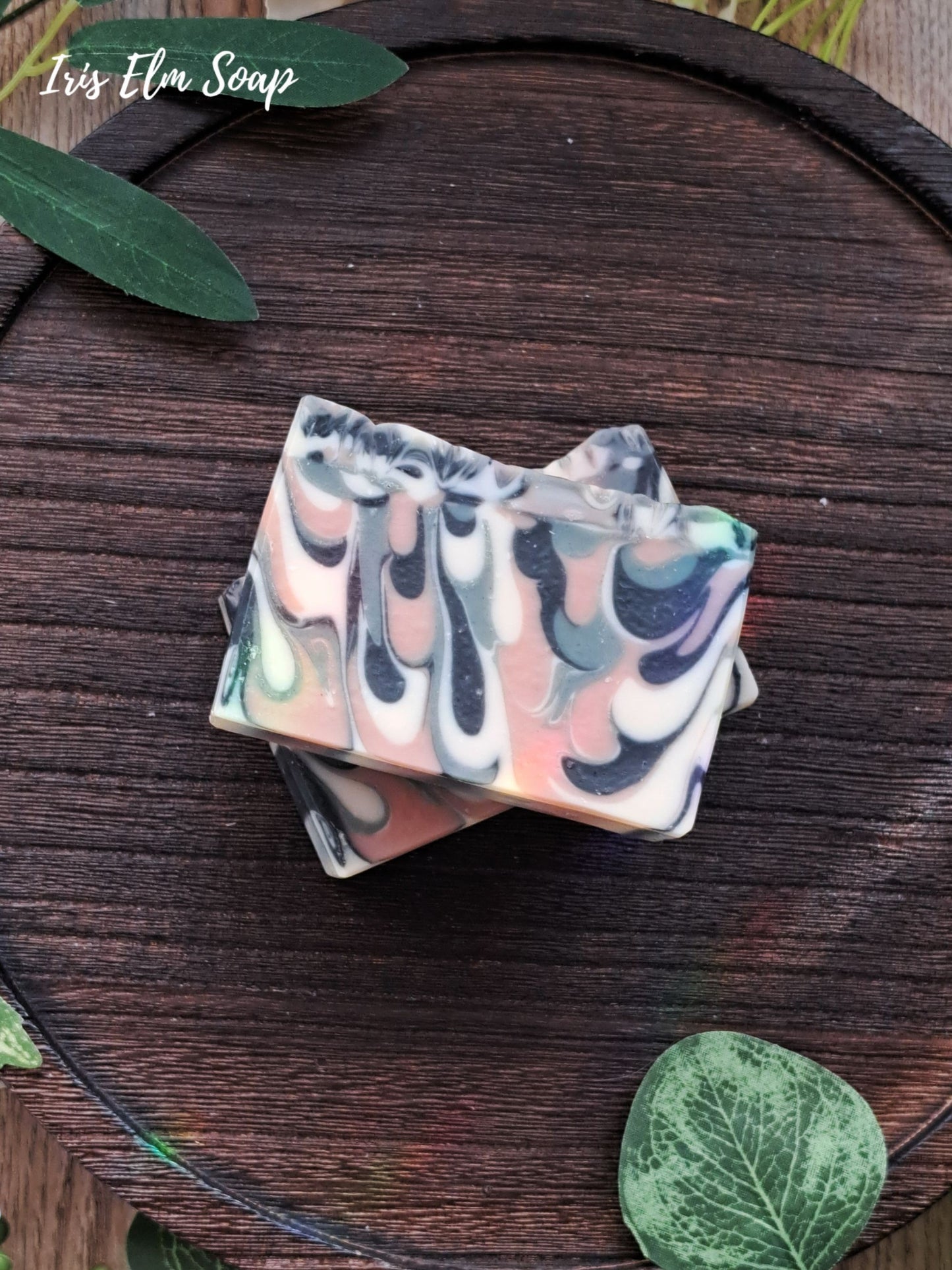 Colorful green tea handmade soap bar with leafy greens on a wooden surface, featuring 'Iris Elm Soap'.