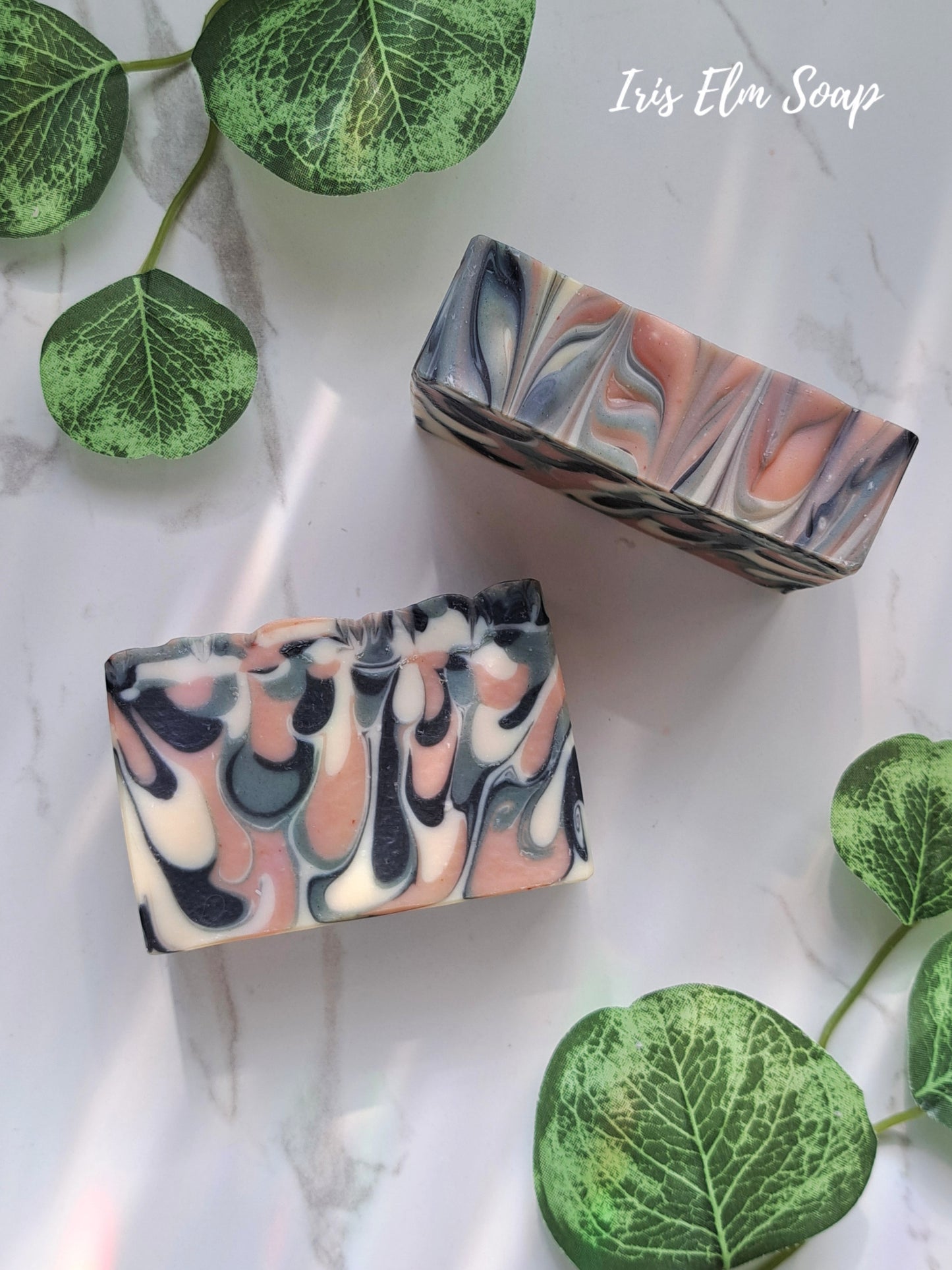 Two marbled green tea handmade soap bars with green leaf decorations on a light background