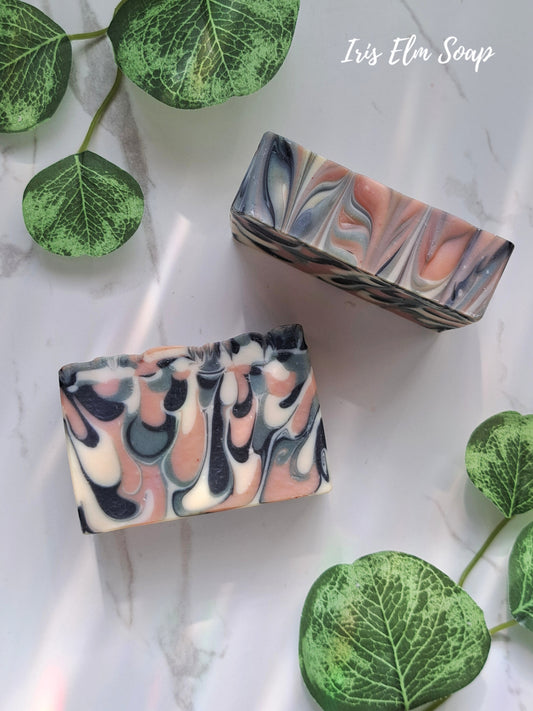 Two marbled green tea handmade soap bars with green leaf decorations on a light background