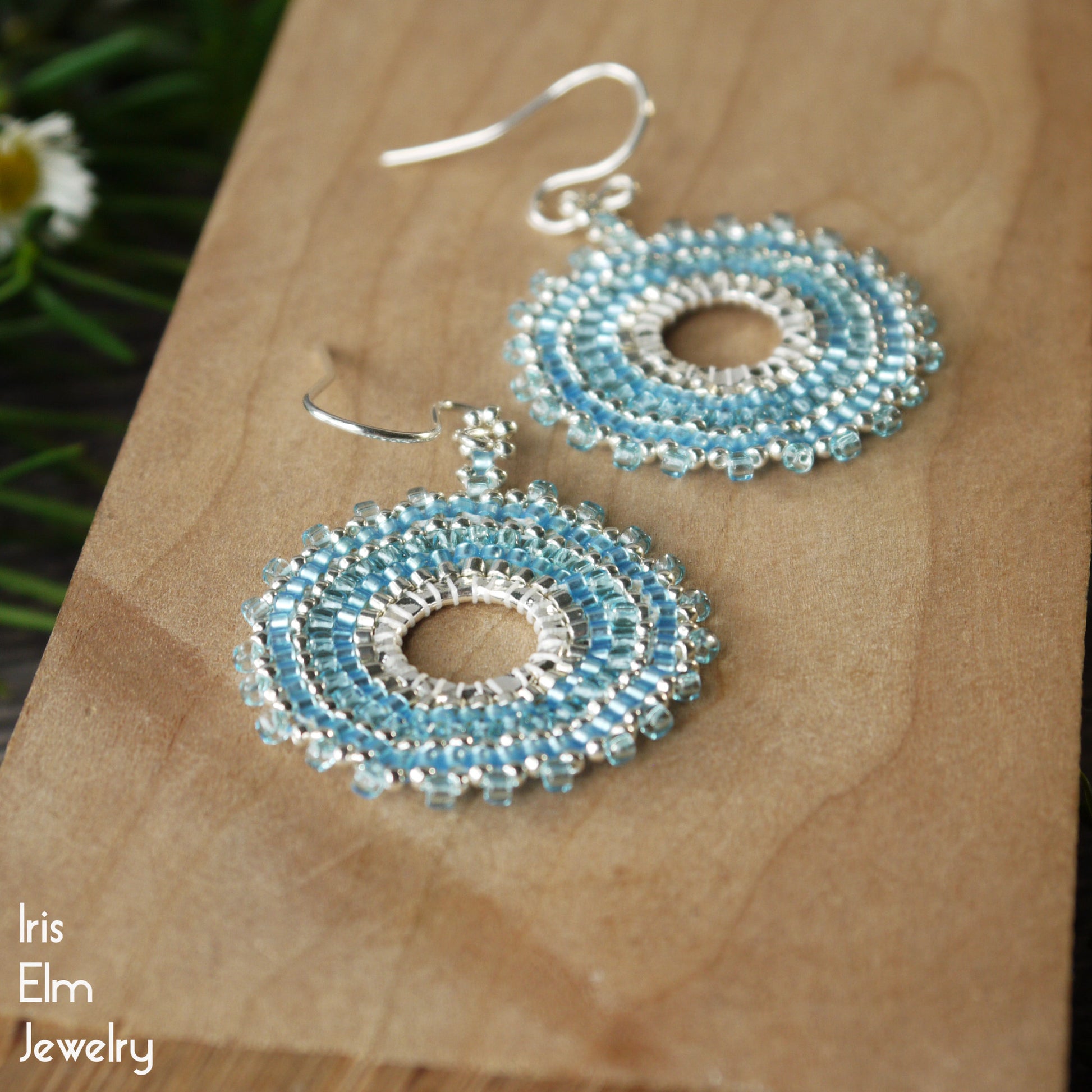 Blue beaded hoop earrings on a wooden surface with 'Iris Elm Jewelry' branding.