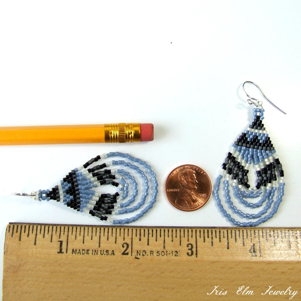 Beaded blue teardrop glass earrings with a pencil and penny for scale, Iris Elm Jewelry