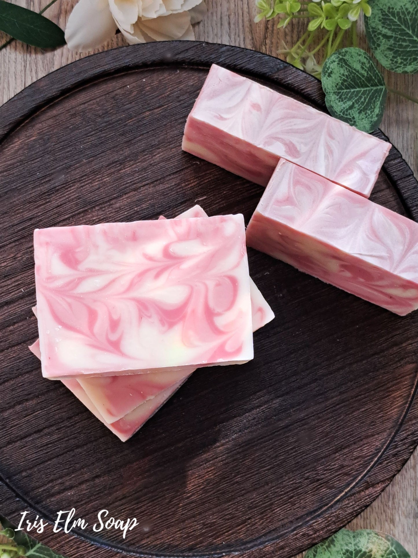 Pink and white marbled citrus love spell handmade soap bars on a wooden surface with 'Iris Elm Soap' branding.
