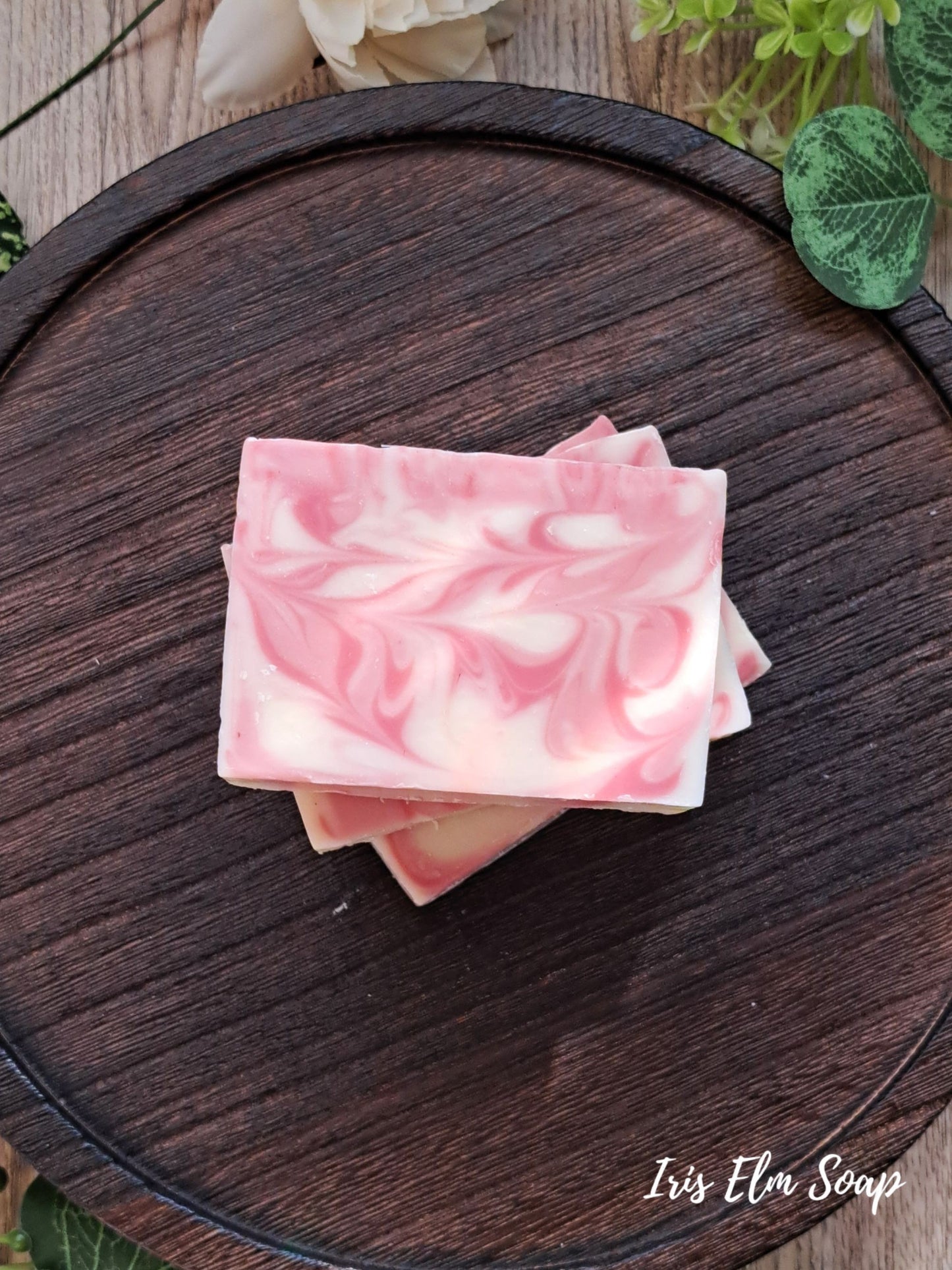 Pink and white marbled citrus love spell handmade soap on a wooden surface with 'Iris Ella Soap' branding.