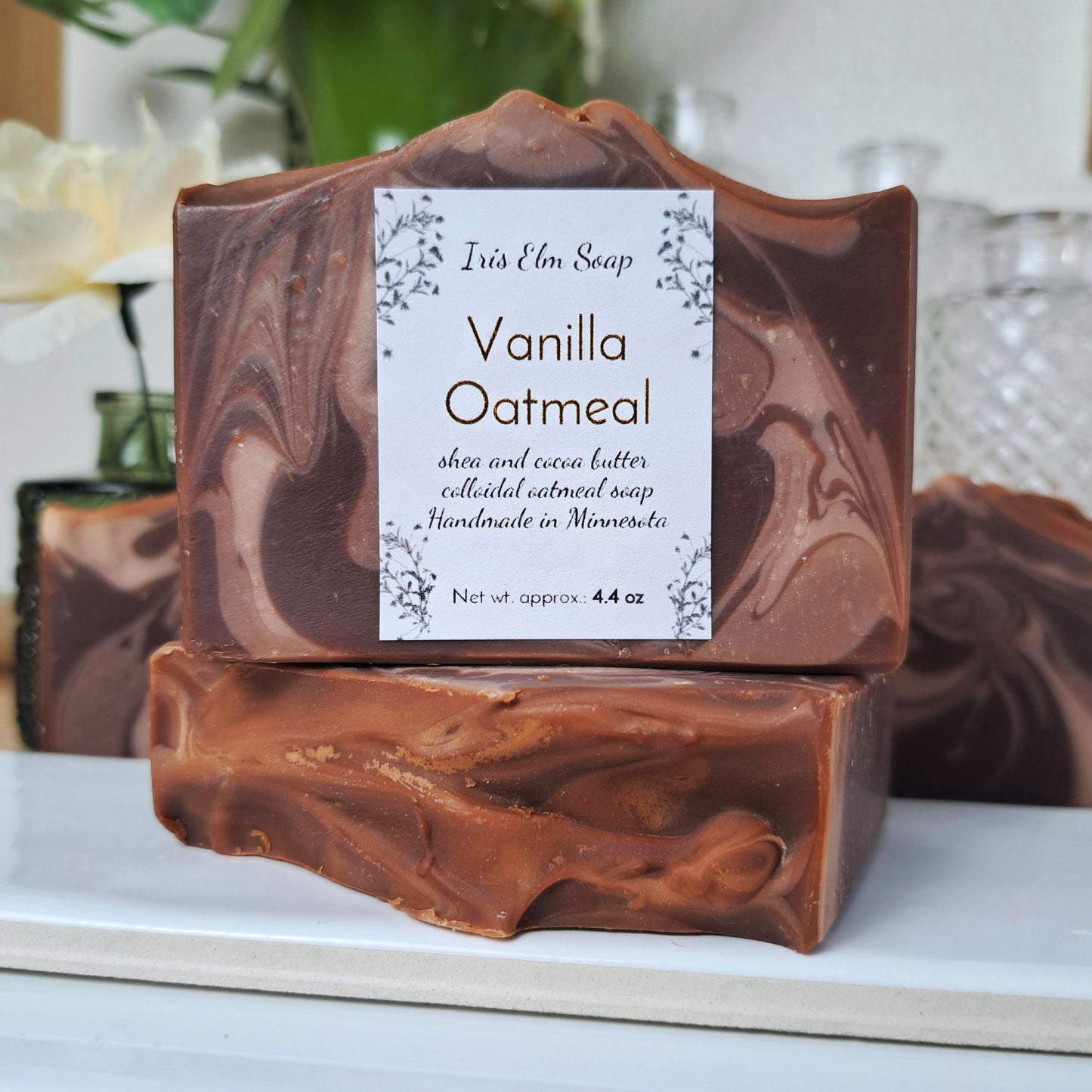 Bar of vanilla oatmeal vegan cold process soap with a made in Minnesota label on a white surface