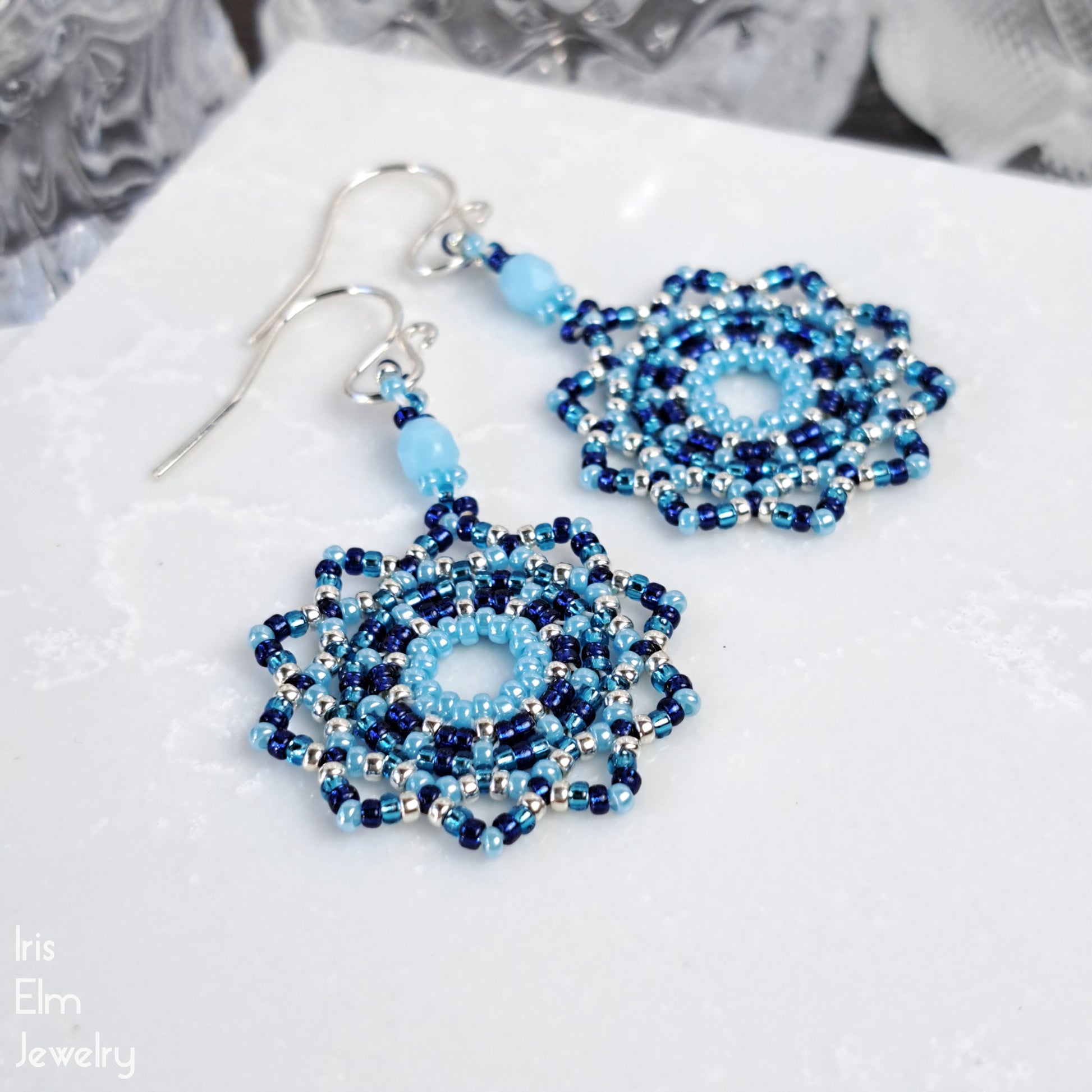 Blue beaded earrings on a white surface with 'Iris Elm Jewelry' branding.