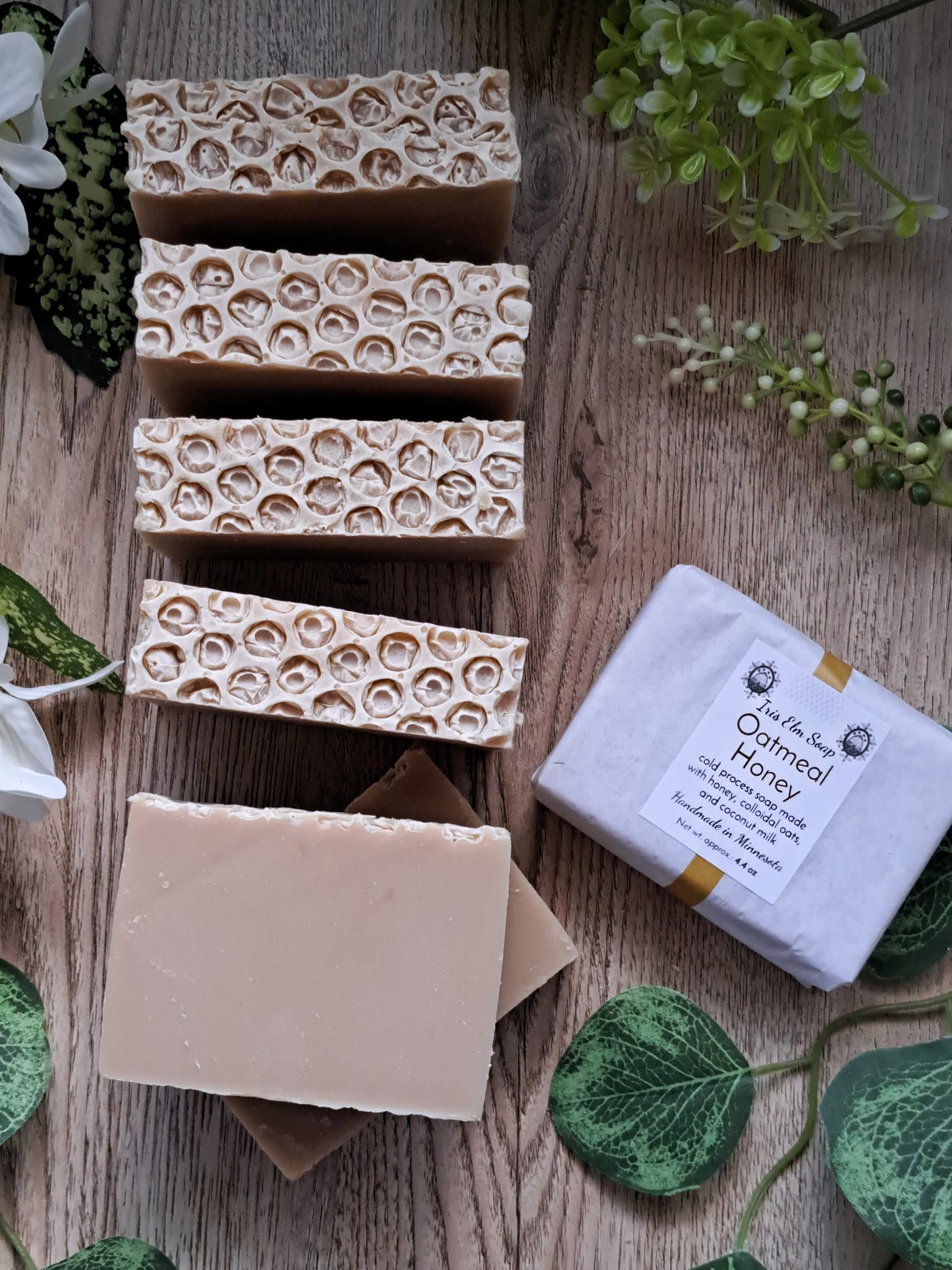 oatmeal honey handmade Bar soaps with a packaging box on a wooden surface with greenery