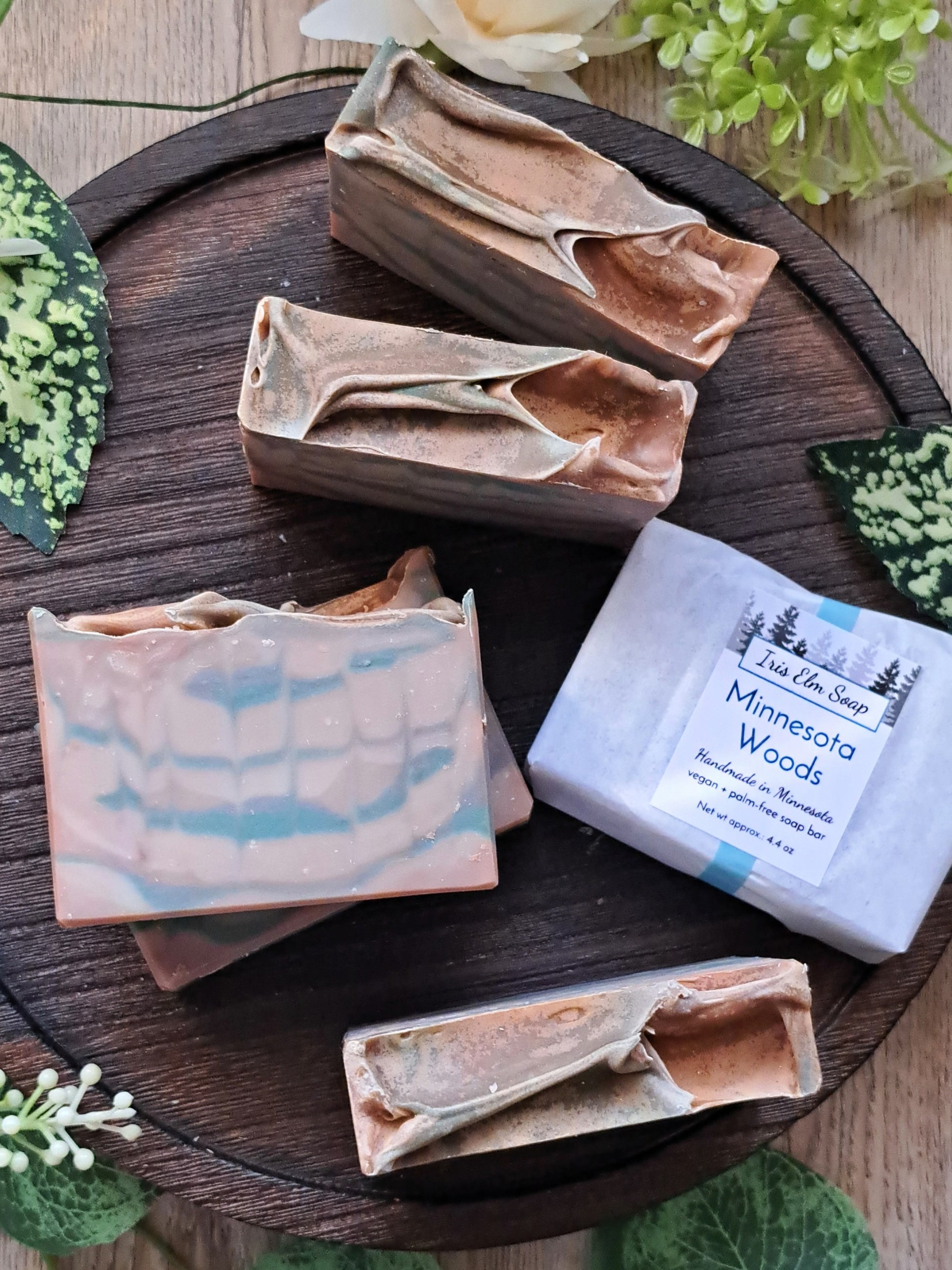 Handmade soap bars on a wooden board with 'Minnesota Woods' soap visible