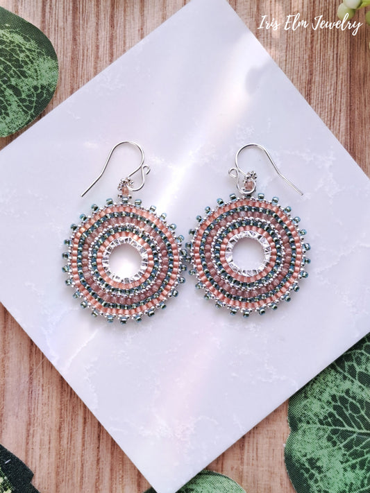 Pair of beaded aqua and peach seed bead woven hoop earrings on a white card with 'Iris Elm Jewelry' branding.