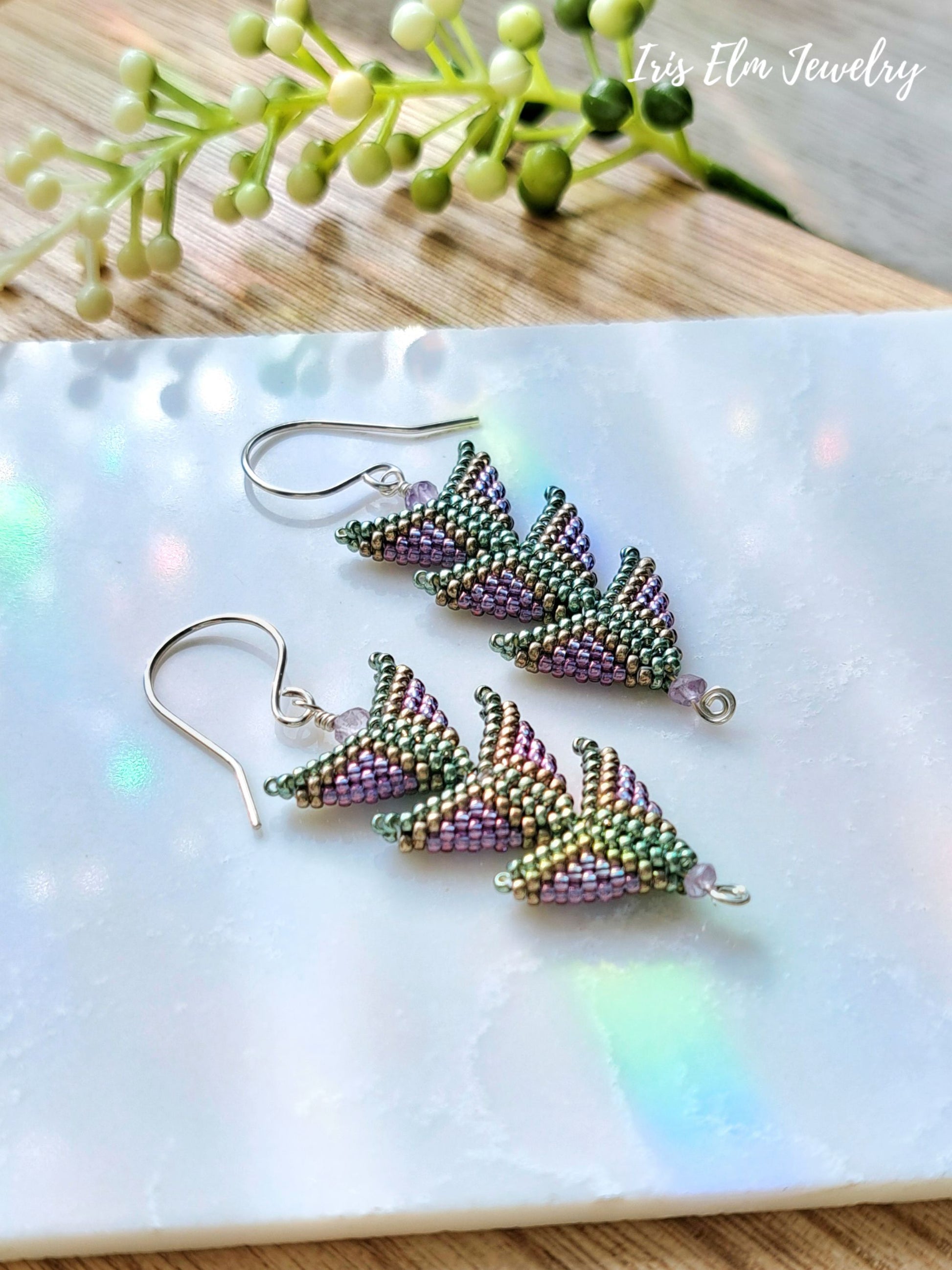 three tier amethyst seed bead purple green handmade beadwork earrings on white marble surface