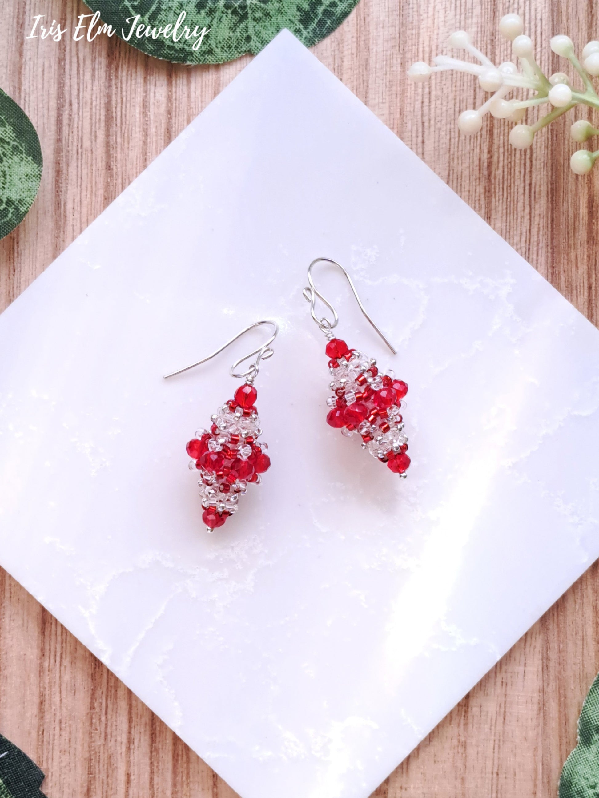 Red and clear glass vintage style beaded earrings on a white tile with 'Iris Elm Jewelry' branding.