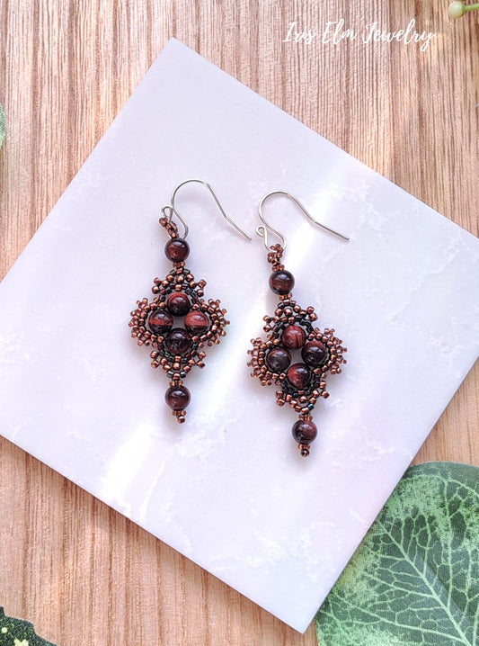 Pair of beaded red tiger eye brown boho earrings on a white square with 'Iris Elm Jewelry' branding.