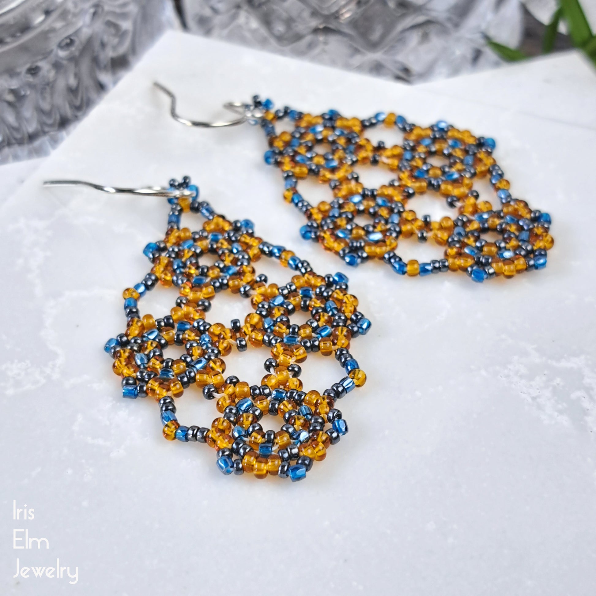 Beaded earrings with blue and orange glass beads on a white background