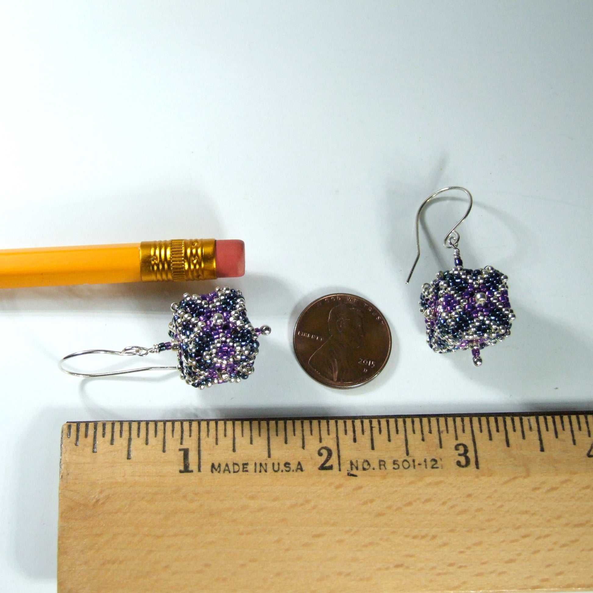 1 and 5/8 inch long Pair of beaded cube shaped earrings next to a pencil and penny on a white background