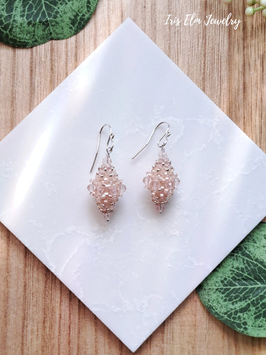 Pair of pale pink beaded bead glass earrings on a white square with 'Iris Elm Jewelry' branding.