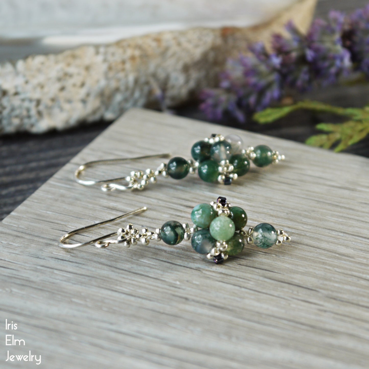 Green beaded earrings on a wooden surface with 'Iris Elm Jewelry' branding.