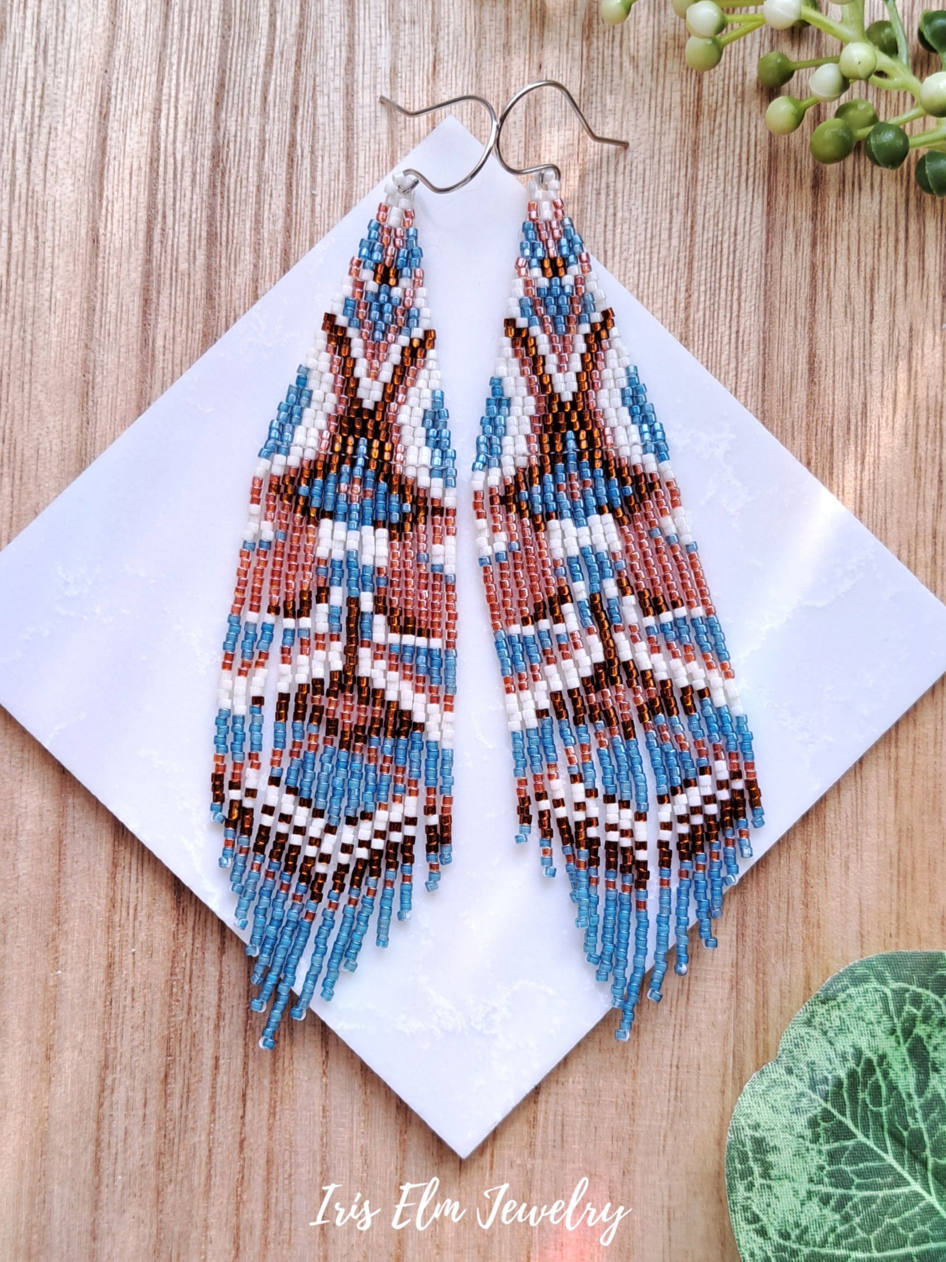 bohemian handmade beadwork blue and brown seed bead fringe earrings on marble surface