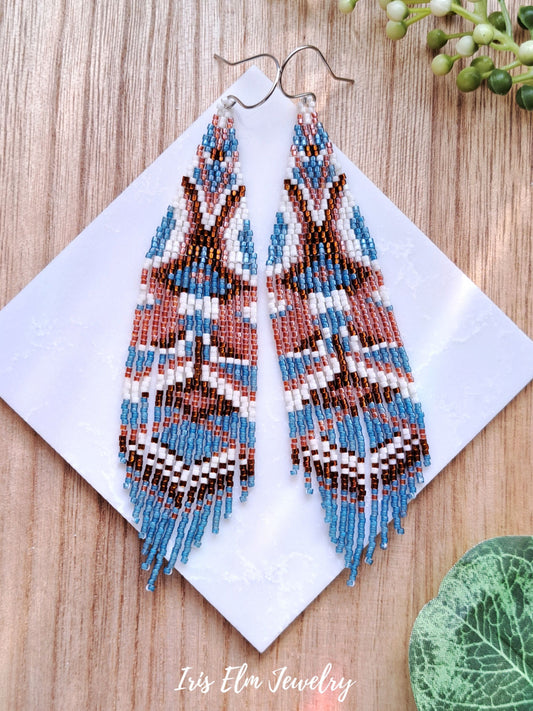 bohemian handmade beadwork blue and brown seed bead fringe earrings on marble surface
