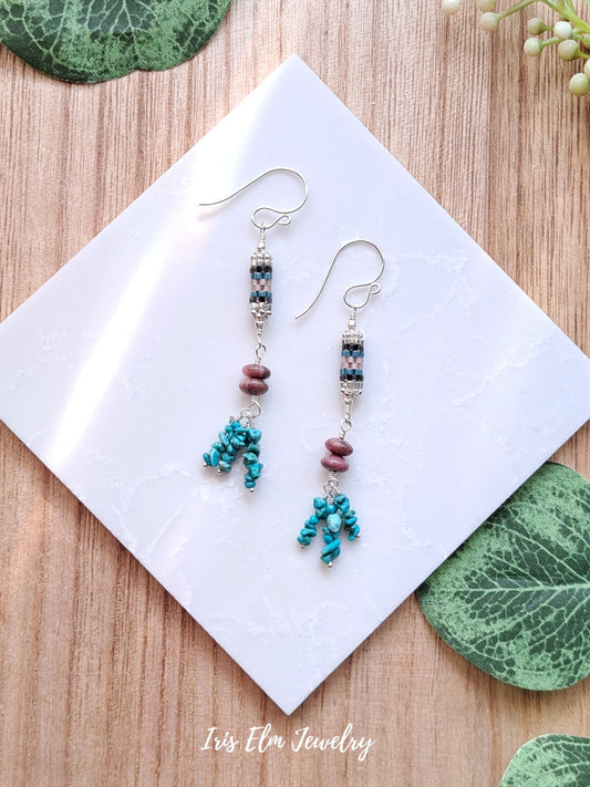 turquoise and pink rhodonite sterling silver Beaded earrings on a white square with green leaves on a wooden surface, featuring 'Iris Elm Jewelry'.