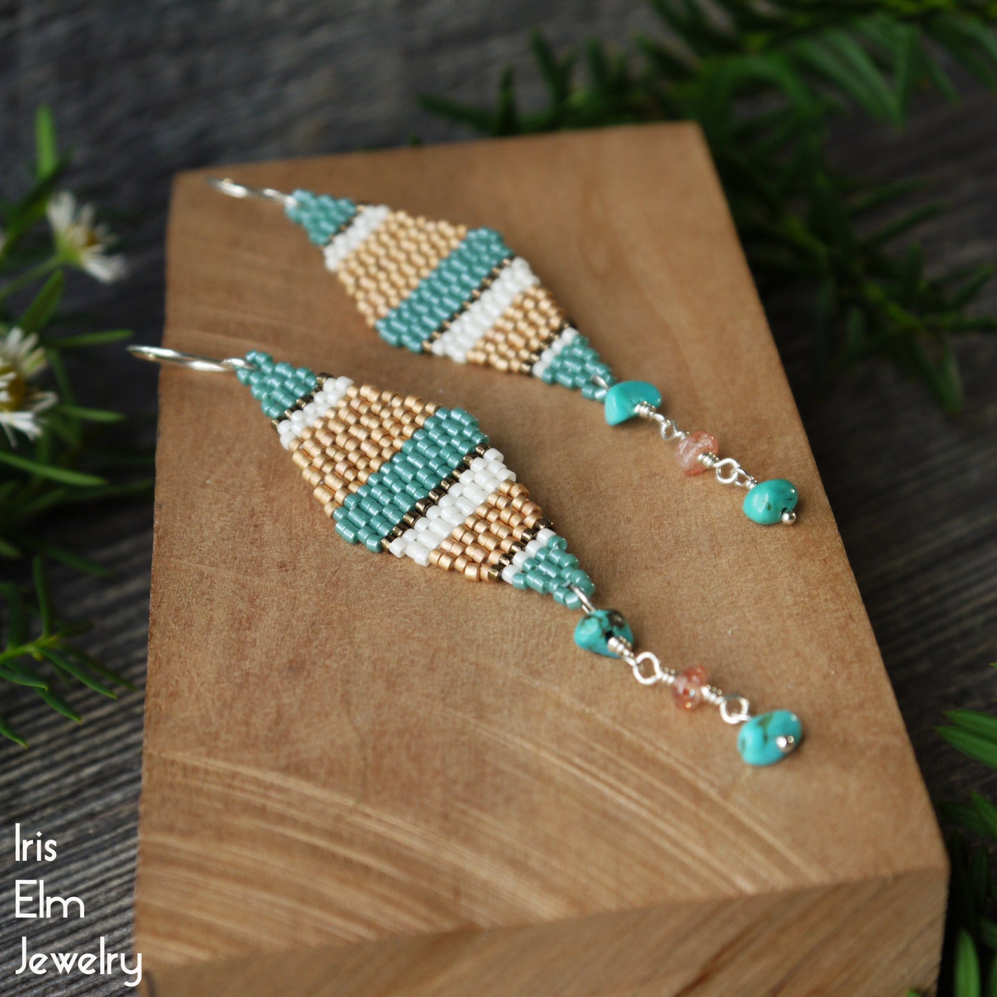 Beaded seed bead and stone beadwork handmade earrings on a wooden block with 'Iris Elm Jewelry' branding.