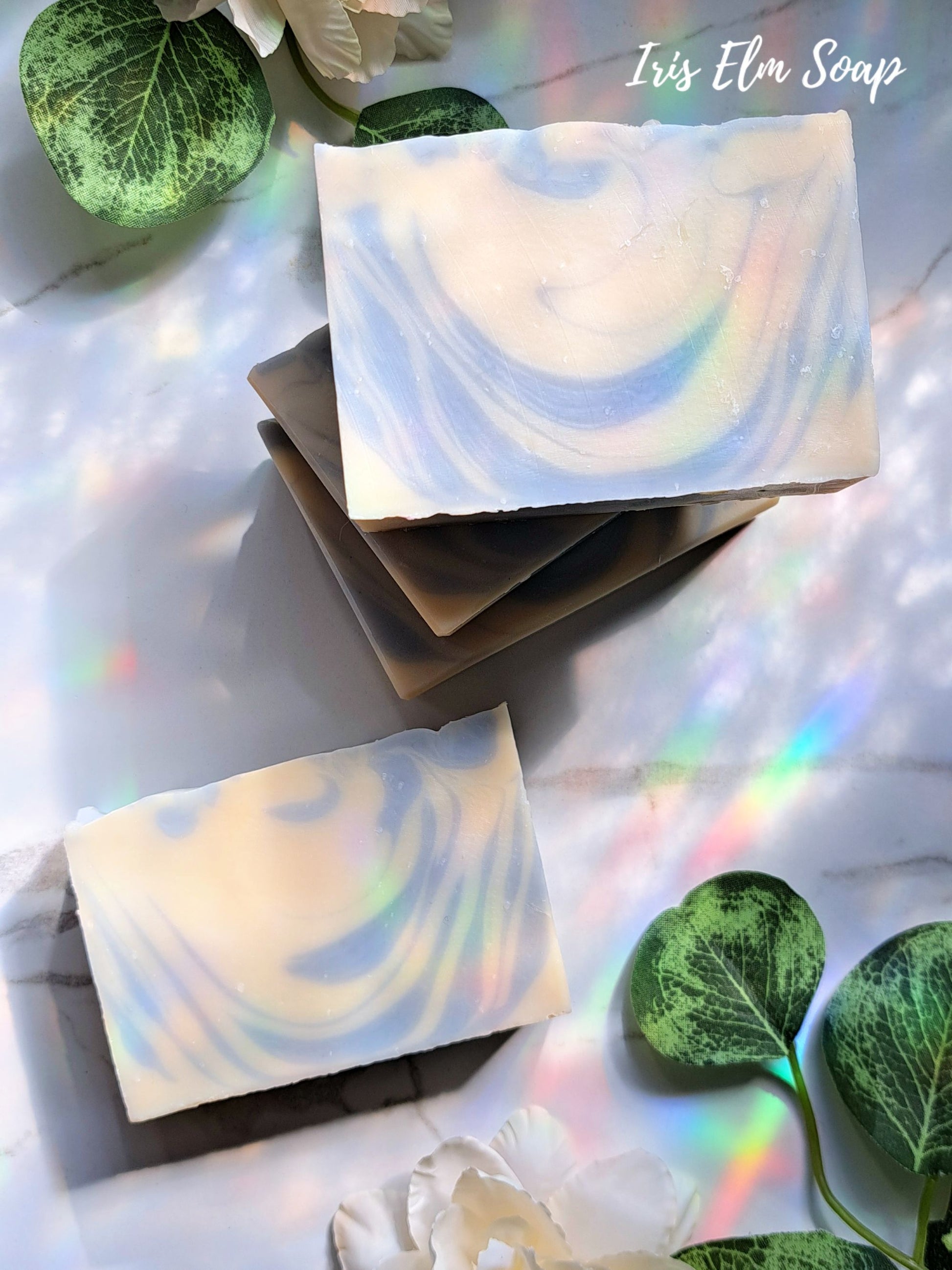 clean cotton handmade soap bars with green leaves on a reflective surface