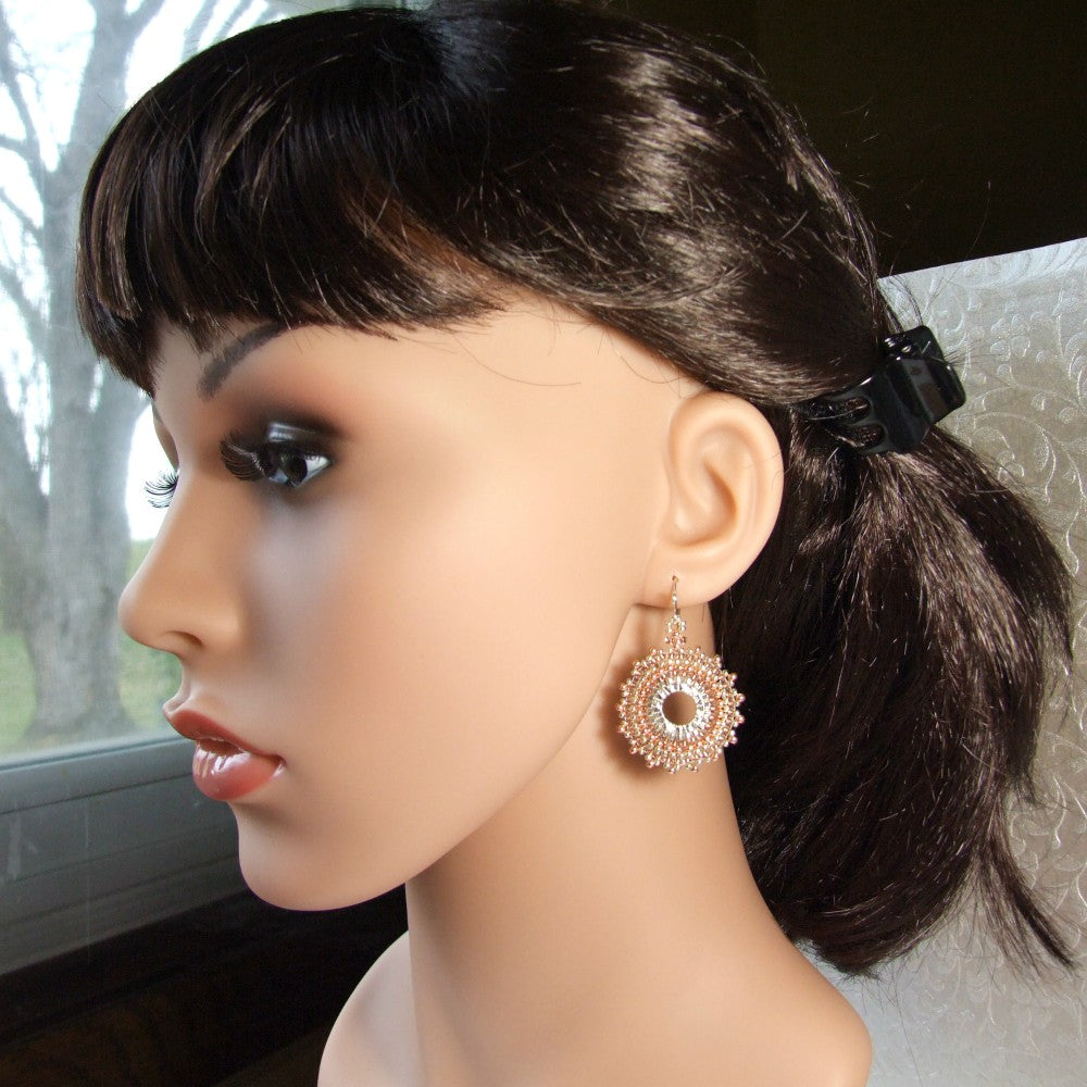 Mannequin head with dark hair styled in a ponytail and wearing a decorative copper hoop seed bead earring.