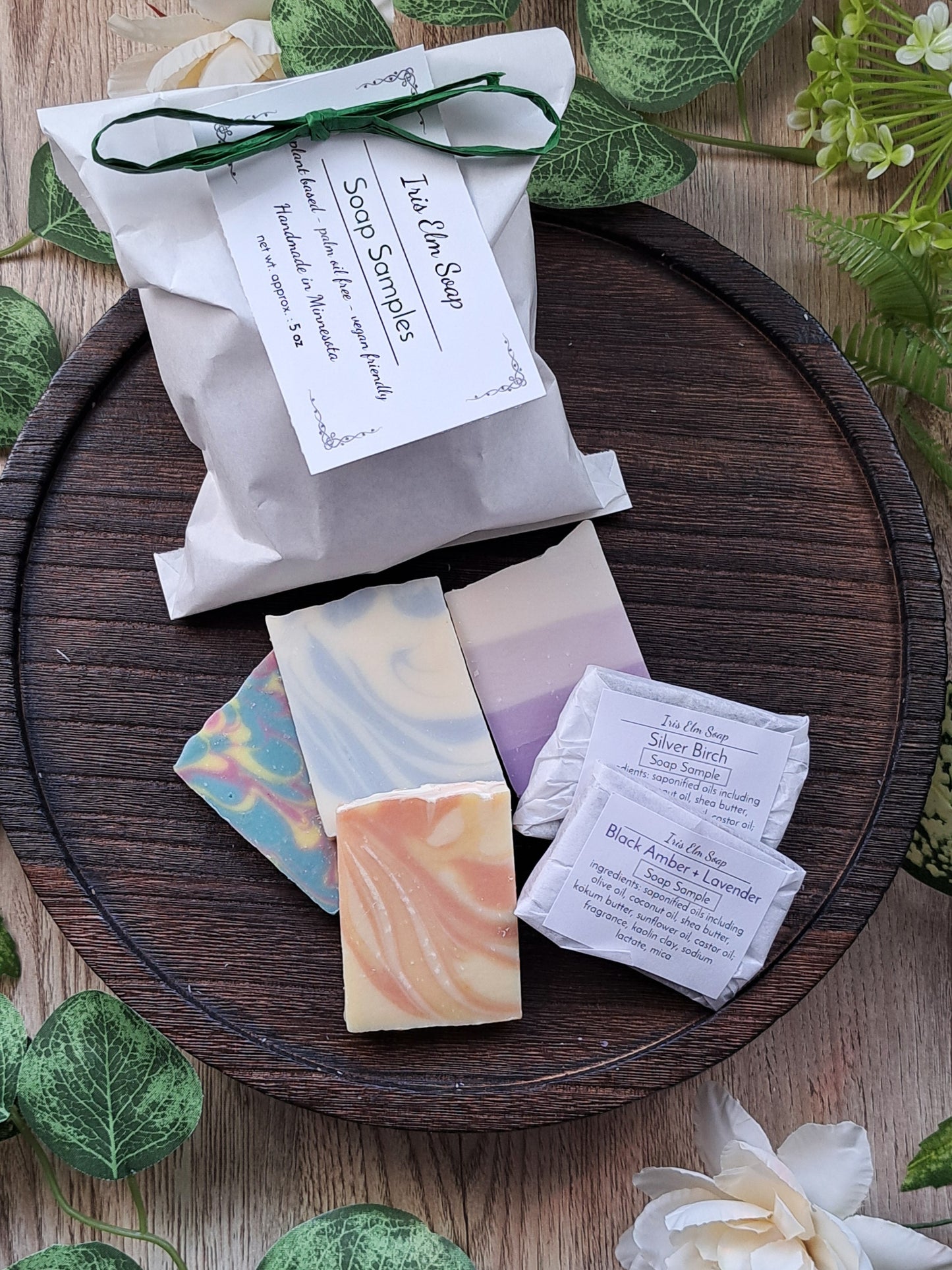 Soap samples on a wooden tray with greenery and flowers