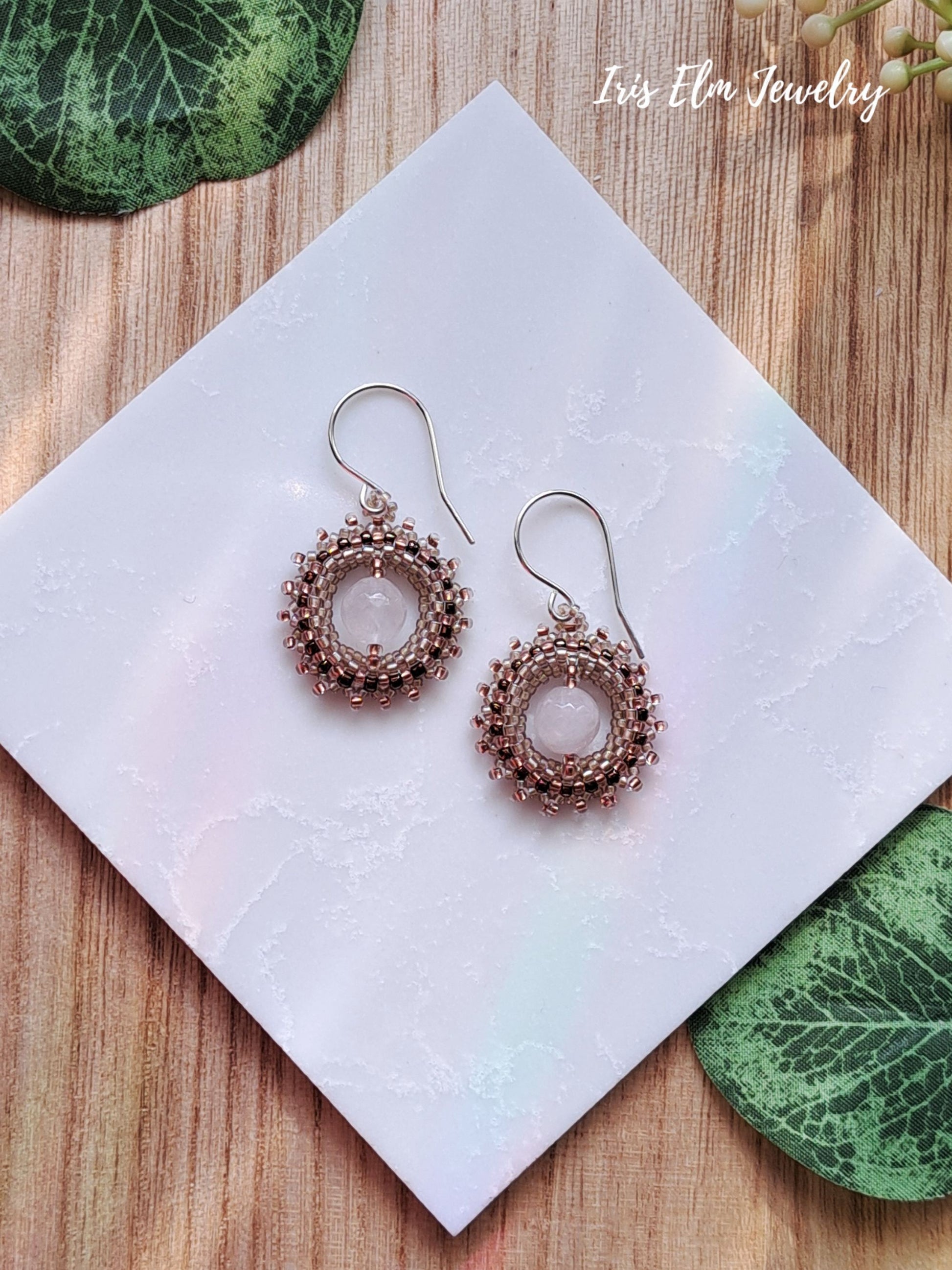 Pair of rose quarts pink wreath seed bead earrings on a white tile with 'Iris Elm Jewelry' branding.