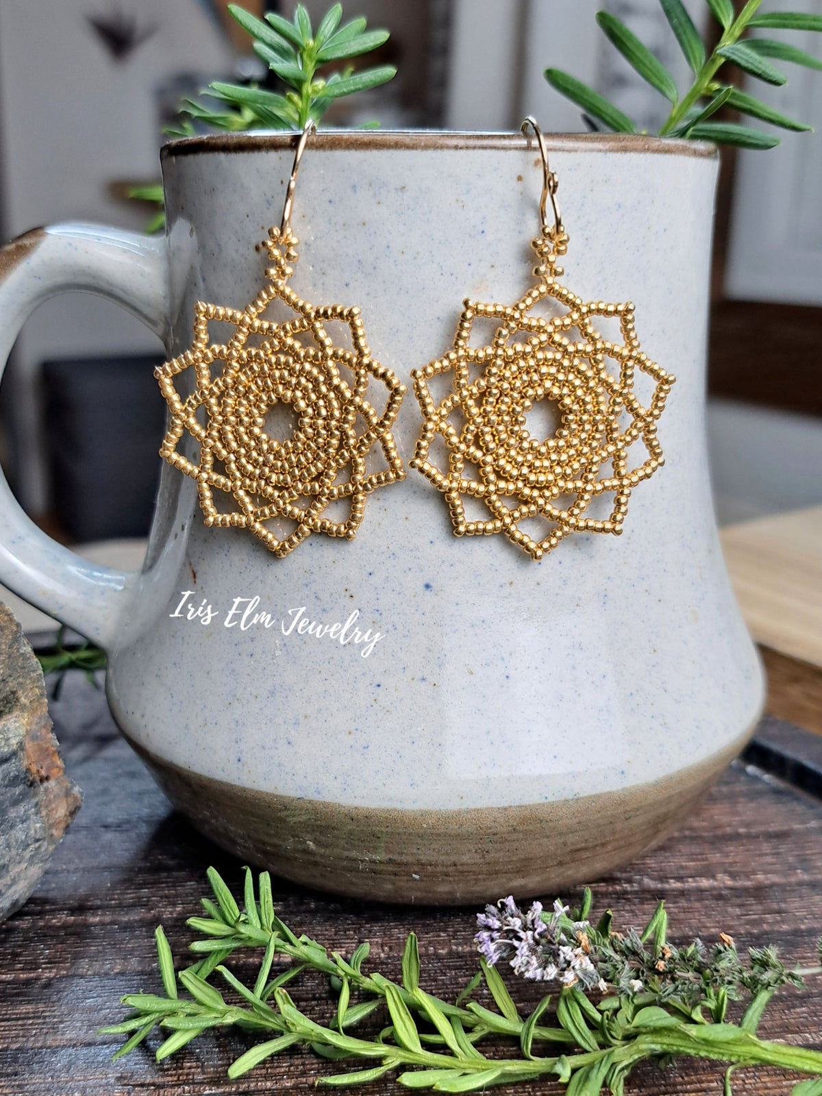 gold seed bead woven mandala handmade earrings by Iris Elm Jewelry on mug